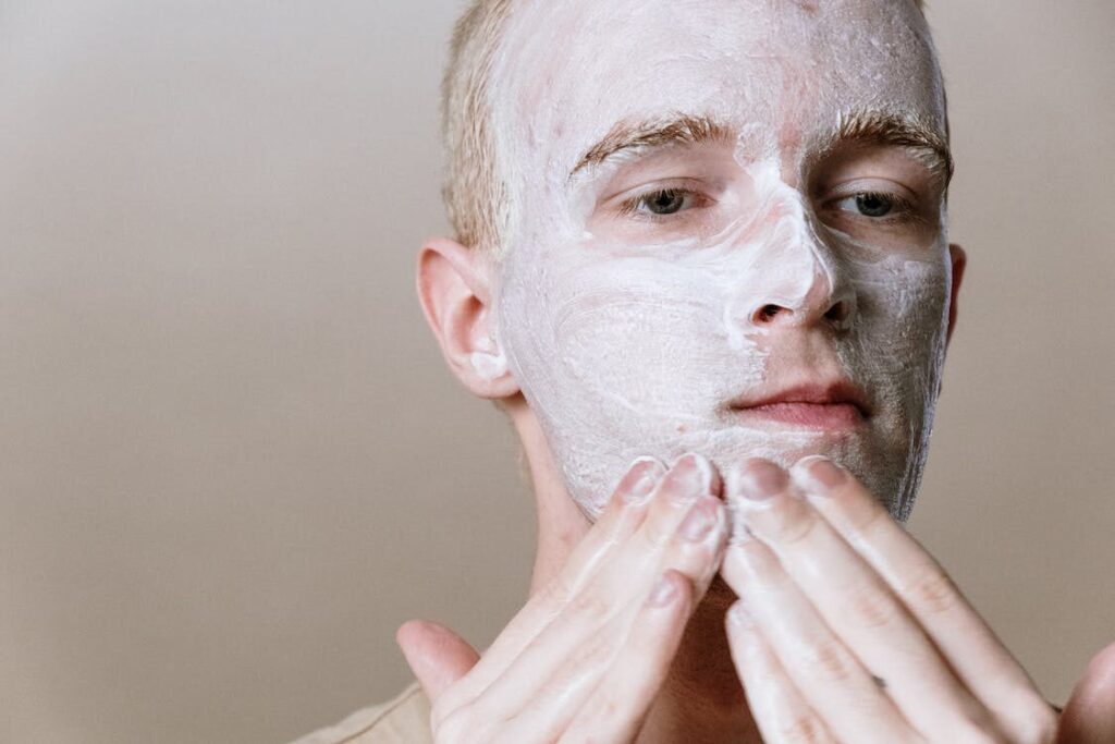 A man is applying a face mask.