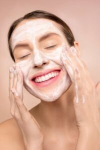 A woman is washing her face