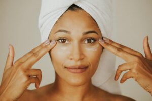 A woman is massaging cream on her face.