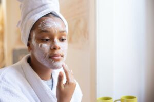 A woman is applying a cleanser to her face.