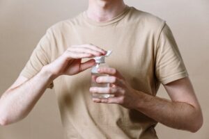 A man is holding a bottle of cleanser.