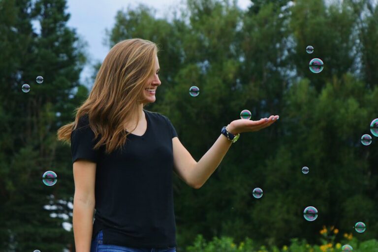 A Woman Plays with Soap Bubbles Outdoors Aces Scalp Health Essentials with Bouncy, Light-brown, Shoulder-length Hair