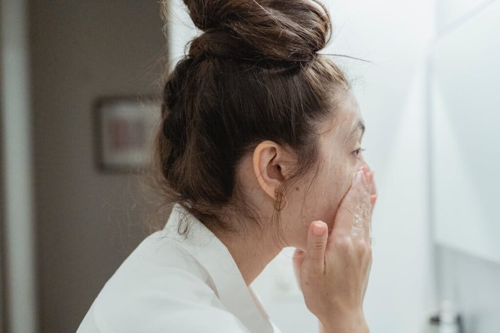  Sideview of a Woman Washes Her Face While Practicing Anti-aging Skincare