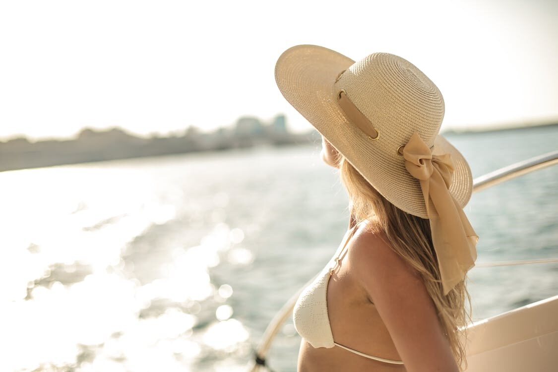  A Woman in a Swimsuit, a Hat, and No Visible Broad Spectrum Protection on a Yacht