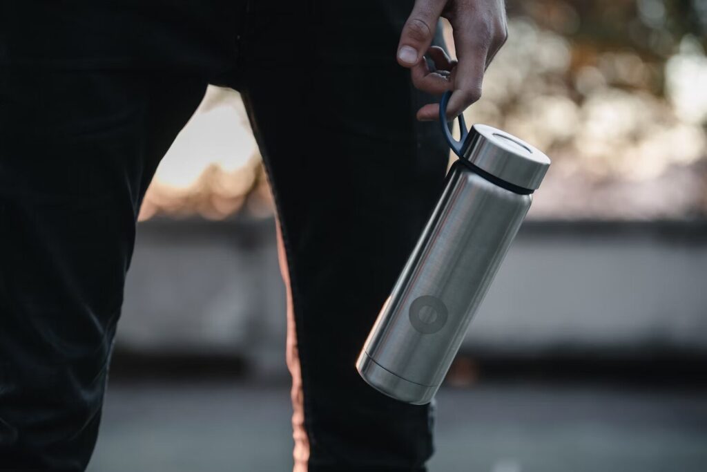 person-holding-stainless-steel-travel-mug