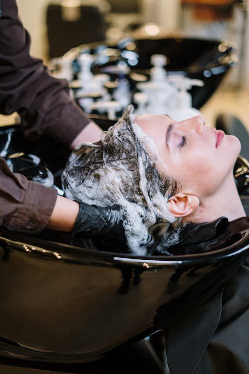  A Woman Looks Blissed Out as She Receives a Hair Wash with a Refreshing Fragrance Shampoo at a Salon