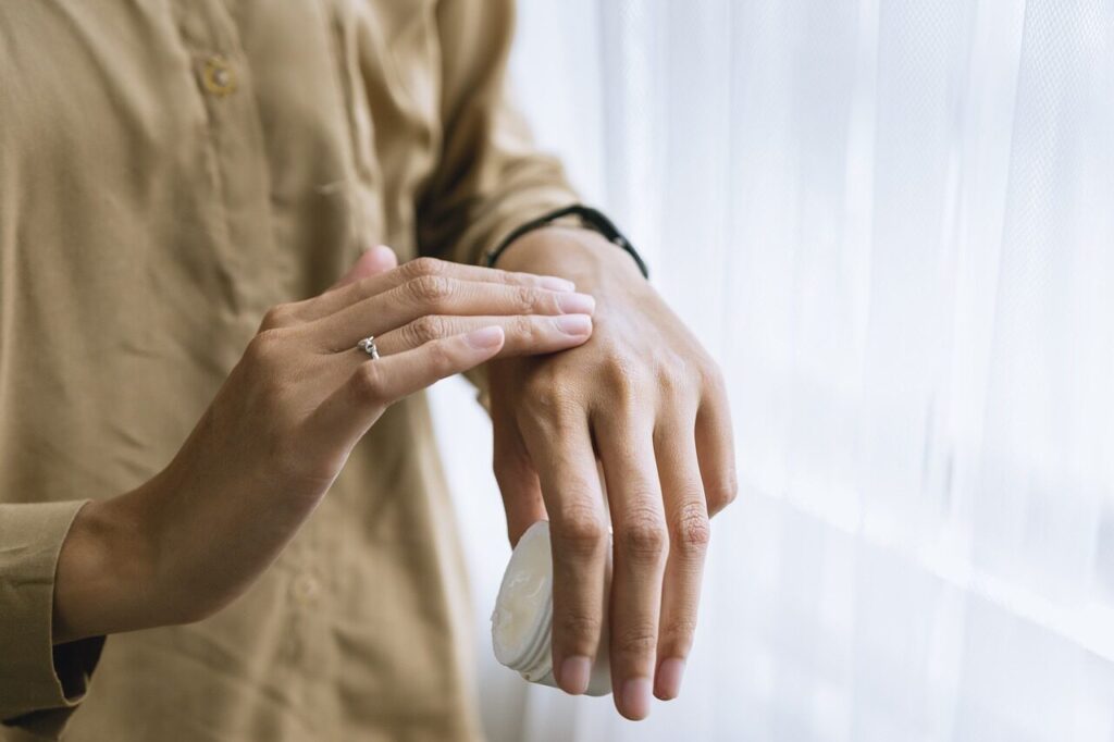 A woman applying a moisturizer on her hands