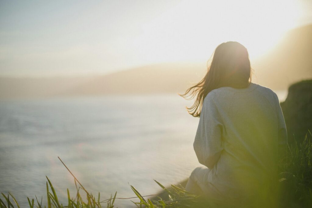 A woman sitting outdoors in sunlight