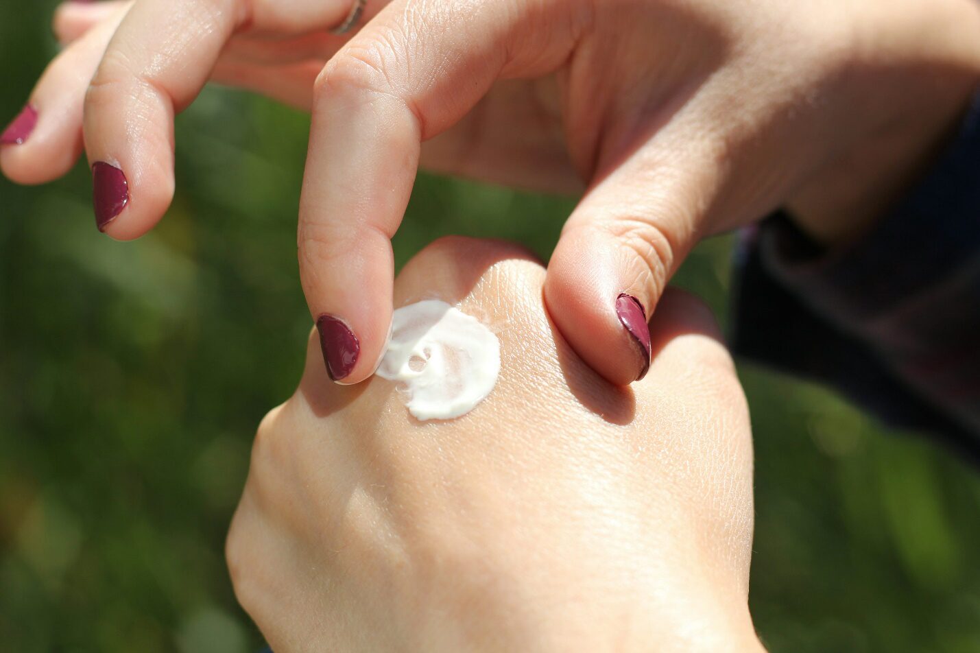 A woman applying lotion on her hands