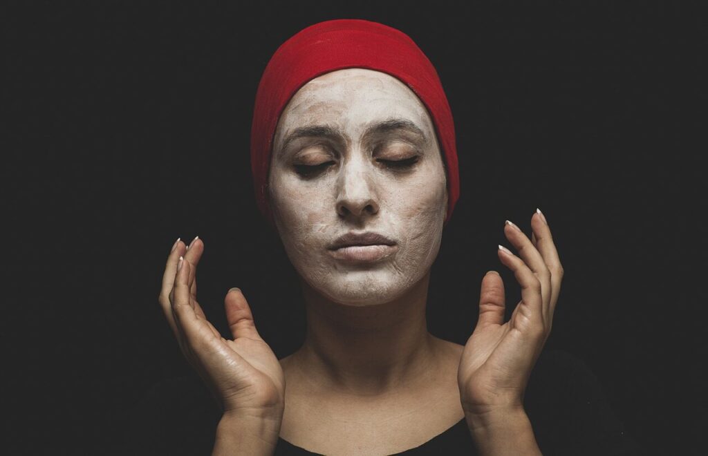 A woman applying a face mask 